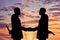 Silhouette of two businessmen shaking hands