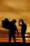 silhouette of two cowboys in the sunset one hold saddle on shoulder