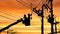 Silhouette two electricians with disconnect stick tool on crane truck are working to install electrical transmission on power pole