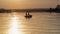 Silhouette of Two Fishermen with Fishing Rods in a Boat in Lake at Sunset