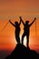 Silhouette of two friends having achievement climbing up mountain to the peak together