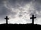 silhouette two grave crosses on cemetery hill among storm motion on dark gray dramatic moody sky