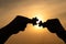 Silhouette of two hands trying to be connecting jigsaw couple puzzle piece with sunset background, Business idea