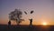 Silhouette of two hikers tourist running jumping funny and throwing backpacks at sunset. Slow motion. Concept travel and