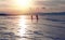Silhouette of two ice skating people at lake Baikal frozen surface on sunset. Winter tourism concept