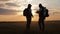 The silhouette of two man standing on the top of mountain with backpacks and use phone for navigation. Lifestyle, travel