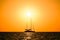 Silhouette of a two-masted yacht at sea on the horizon background of the setting sun