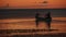 Silhouette of two men in a boat in the sea at sunset