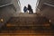 Silhouette of two passengers with their suitcases trolley climbing a ladder