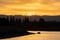 Silhouette of two people on boat on the shoreline lake in California at sunset