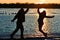 Silhouette Two People Leaping by Lake, Sunset