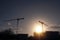 Silhouette of a two tall crane and construction site for commercial office of residential property. Construction industry. Modern