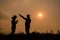 Silhouette of two teen girls praying to god with the bible