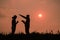 Silhouette of two teen girls praying to god with the bible