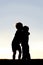 Silhouette of Two Young Children Hugging at Sunset