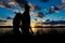 Silhouette of two young women, in front of a dramatic and beautiful sunset by the Hudson River , Upstate New York, NY