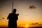 Silhouette of an unidentified person playing the Berimbau against the sunset