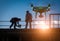 Silhouette of Unmanned Aircraft System Drone UAV Quadcopter Drone In The Air Over Building Under Construction