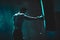 Silhouette of an unrecognizable boxer man sparring with a punching bag in a dark gym. Male athlete working out in