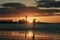 Silhouette of unrecognizable person walking on Mangalsala pier through the waves in sunset.