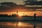 Silhouette of unrecognizable person walking on Mangalsala pier through the waves in sunset.