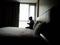 Silhouette of Upset Woman Sitting using the phone in Bed, lonely, alone