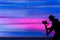 Silhouette of videographer is filming with cinema gimbal video dslr, professional video, videographer in events. Violet background