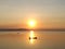 Silhouette view of beautiful sunset over the lake having boat in middle of sun reflection in summer