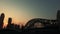 Silhouette view of bridge and skyscrappers at sunset