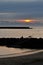 Silhouette view of jetty during a cloudy sunset