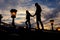 Silhouette of the walking couple by the hand along the Chain Bridge full of lightning street lamps in Budapest, Hungary