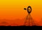 Silhouette of a water pumping windmill at the desert