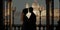 Silhouette of wedding couple on their honeymoon hugging kissing on a terrace in the evening with Venice background