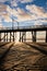 Silhouette of White Rock pier from rippled sandy beach