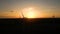 Silhouette of a windmill in the sun. Aerial close up shot of wind mills rotating by the force of the wind and generating renewable