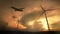 Silhouette of Windmills for electric power production and Airplane take off on the Colorful dramatic sky with cloud at sunset