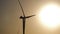 Silhouette windmills for electric power production in the meadow at sunset. Group of windmills for renewable electric