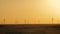 Silhouette windmills for electric power production in the meadow at sunset. Group of windmills for renewable electric