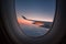 Silhouette wing of an airplane at sunrise view through the window