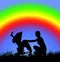 Silhouette of a woman with a baby stroller on a background of rainbow