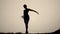 Silhouette of woman ballerina gracefully and smoothly dances outdoors background sky, front view. Female ballerina
