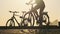 Silhouette of Woman on Bicycle Rides by Bike Path in Park at Sunset Slow Motion