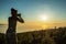 Silhouette of woman with camera. Woman takes photo of La Gomera Island in the rays of the setting sun. Tenerife Island