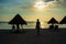 Silhouette of woman  carrying their shoes on sunset beach