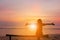 Silhouette of Woman Celebration Success Happiness Relaxed on a Wooden Evening Sky Sunset at the Beach Background, Sport and active