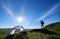 Silhouette of woman climber near camping against blue sky in the morning