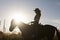 Silhouette of a woman in cowboy hat riding a horse - sunset or sunrise, horizontal