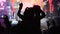 Silhouette of Woman in Crowd at Rock Concert Showing Sign Devil`s Horns Gesture
