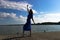 Silhouette of the woman dancing at the beach during beautiful sunrise. Natural light and darkness