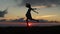 Silhouette of the woman dancing at the meadow field during sunrise. Happy woman silhouette jumping and enjoying life.